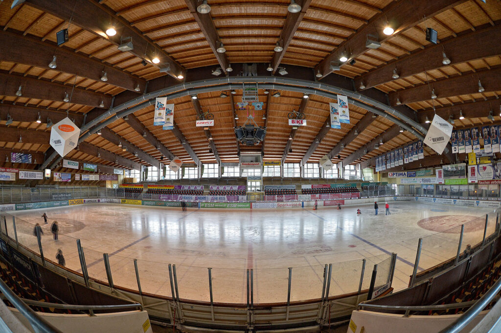 Netzsch-Arena in Selb: Innenaufnahme einer Eishalle mit Holzbalkendecke, Bannerwerbung, Tribünen und Eisfläche – Blick über das Hallenambiente im Dreiländereck Franken.