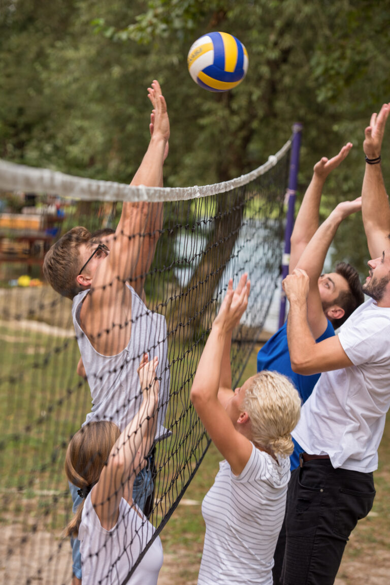 Gruppe junger Freunde spielt Beach-Volleyball im Freien am Netz im Fichtelgebirge
