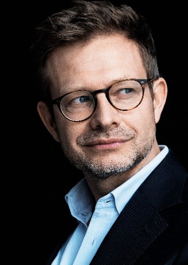 Porträt von Florian Illies mit Brille und offenem hellblauem Hemd bei der Kulturreihe im Hotel Morgenland